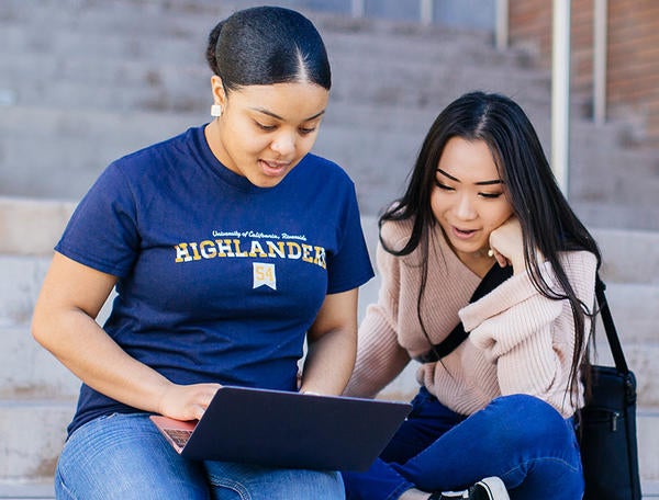 students sitting on steps with laptop (c) UCR