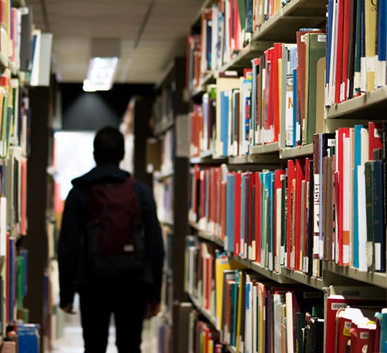 student in library (c) unsplash